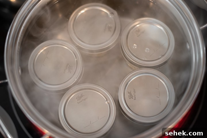 Low-Sugar Strawberry Jam Recipe — Small-Batch Preserving Tips 8 Boiling homemade jam in jars to seal the tops.