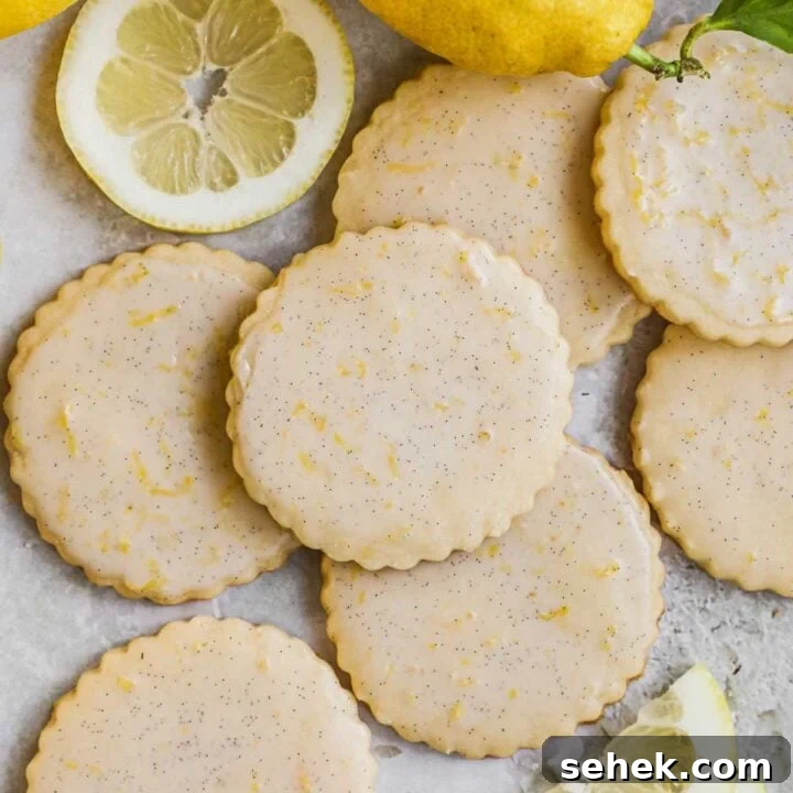 Lemon shortbread cookies with lemon vanilla bean glaze with bits of lemon zest and sliced lemons.
