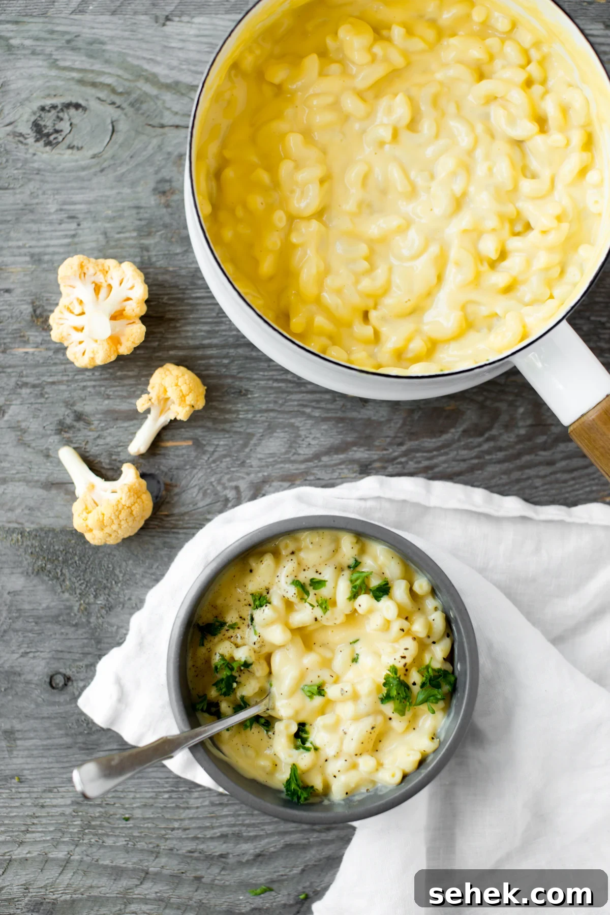 Creamy Stovetop Cauliflower Mac and Cheese Recipe 5 bowl of stovetop cauliflower mac and cheese with parsley and gray background