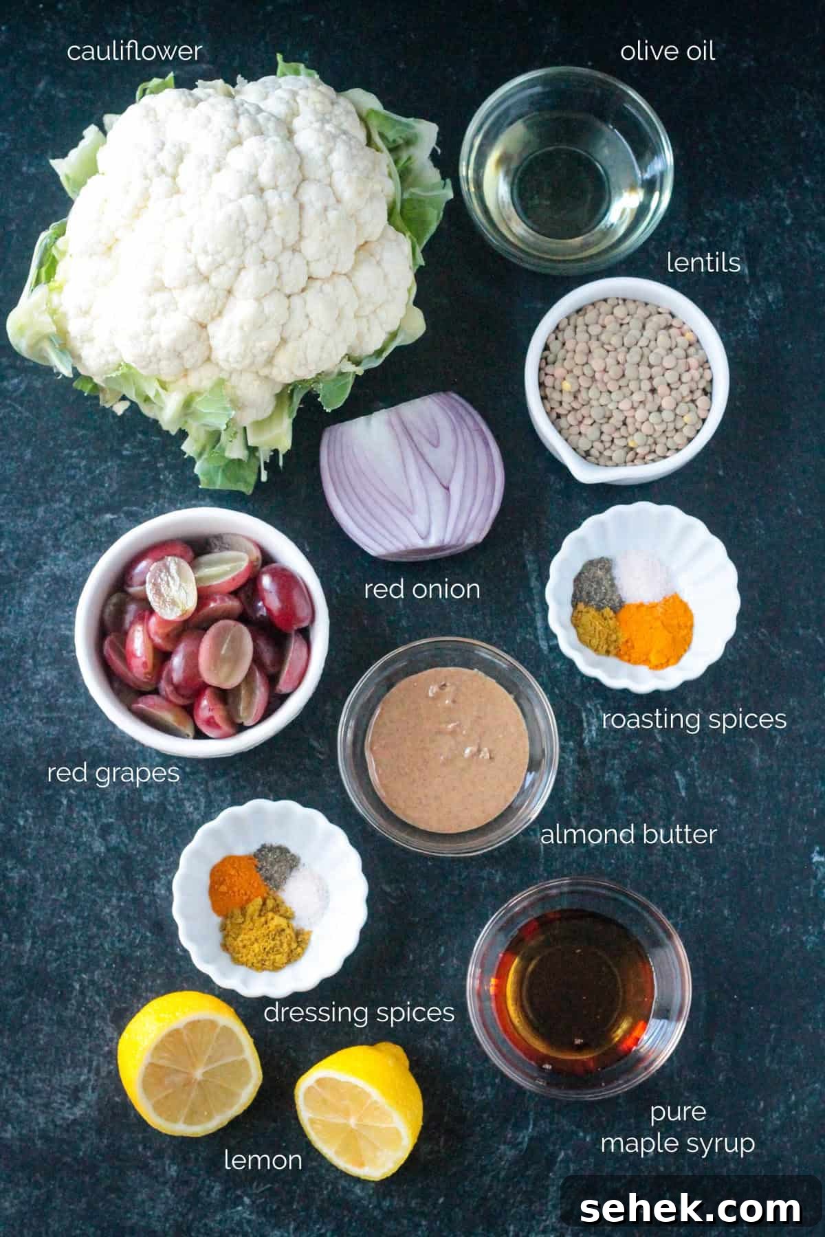 Roasted Cauliflower Salad - cauliflower tossed with turmeric & curry powder, roasted until tender and golden, and then tossed with protein-packed lentils and sweet, juicy grapes. It's flavor and texture dynamite! A light, yet filling, meatless meal or side dish. Recipe ingredients arrayed in individual bowls.