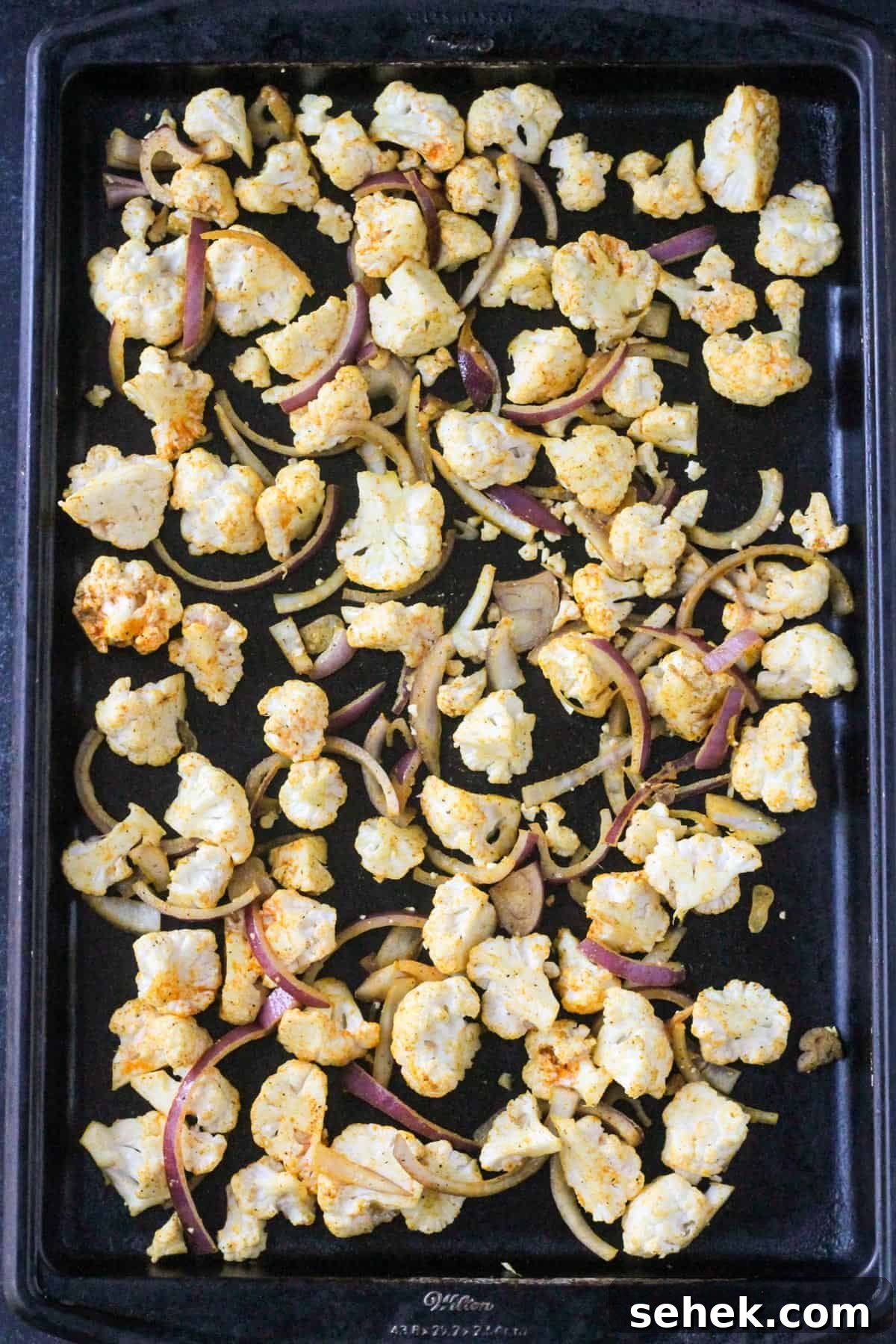 Curry-Roasted Cauliflower Salad with Lemon Tahini Dressing 5 Chopped veggies on a sheet pan ready to bake.