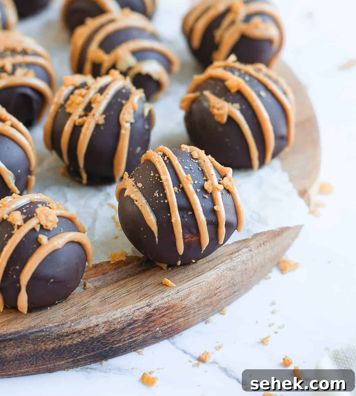 No-Bake Chocolate Peanut Butter Balls Recipe That Melts in Your Mouth 6 Peanut Butter Balls over a round wooden board.