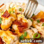 Creamy Loaded Cauliflower Casserole with Bacon and Cheddar 11 Baked cauliflower casserole on a white plate.