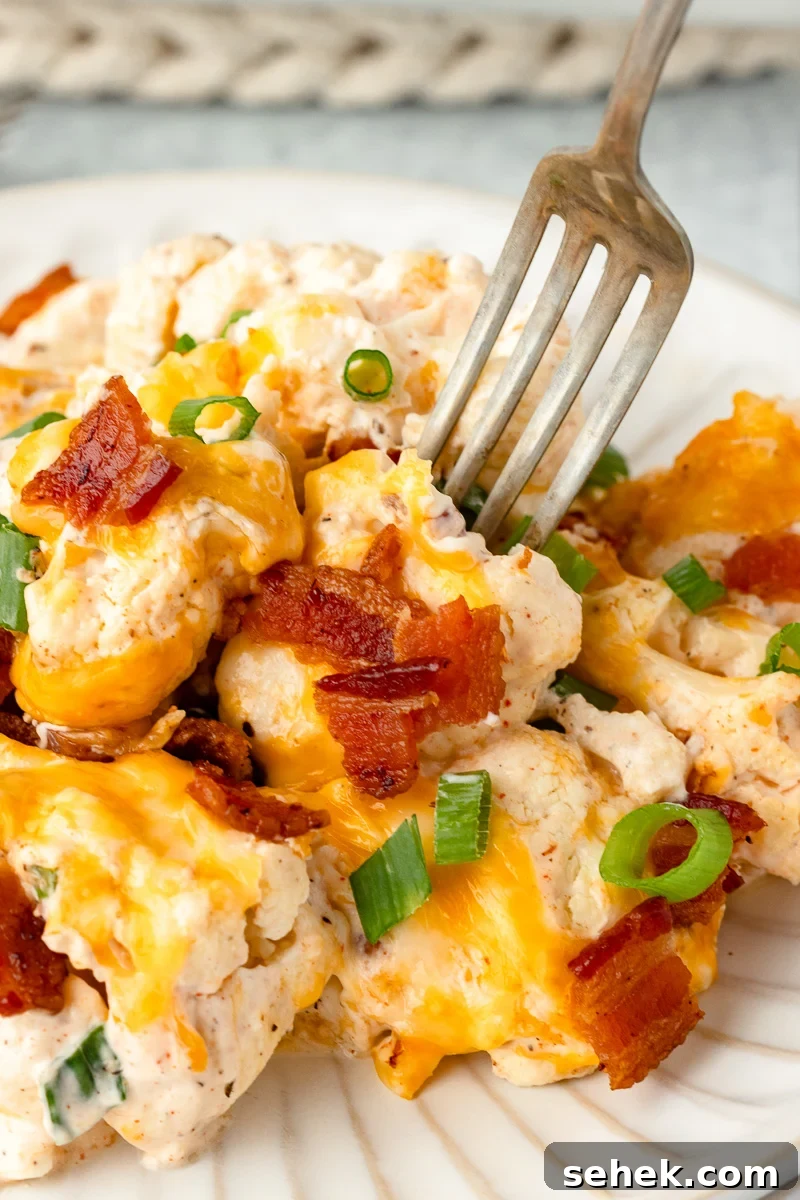 Creamy Loaded Cauliflower Casserole with Bacon and Cheddar 3 Loaded cauliflower casserole on a plate with a fork.