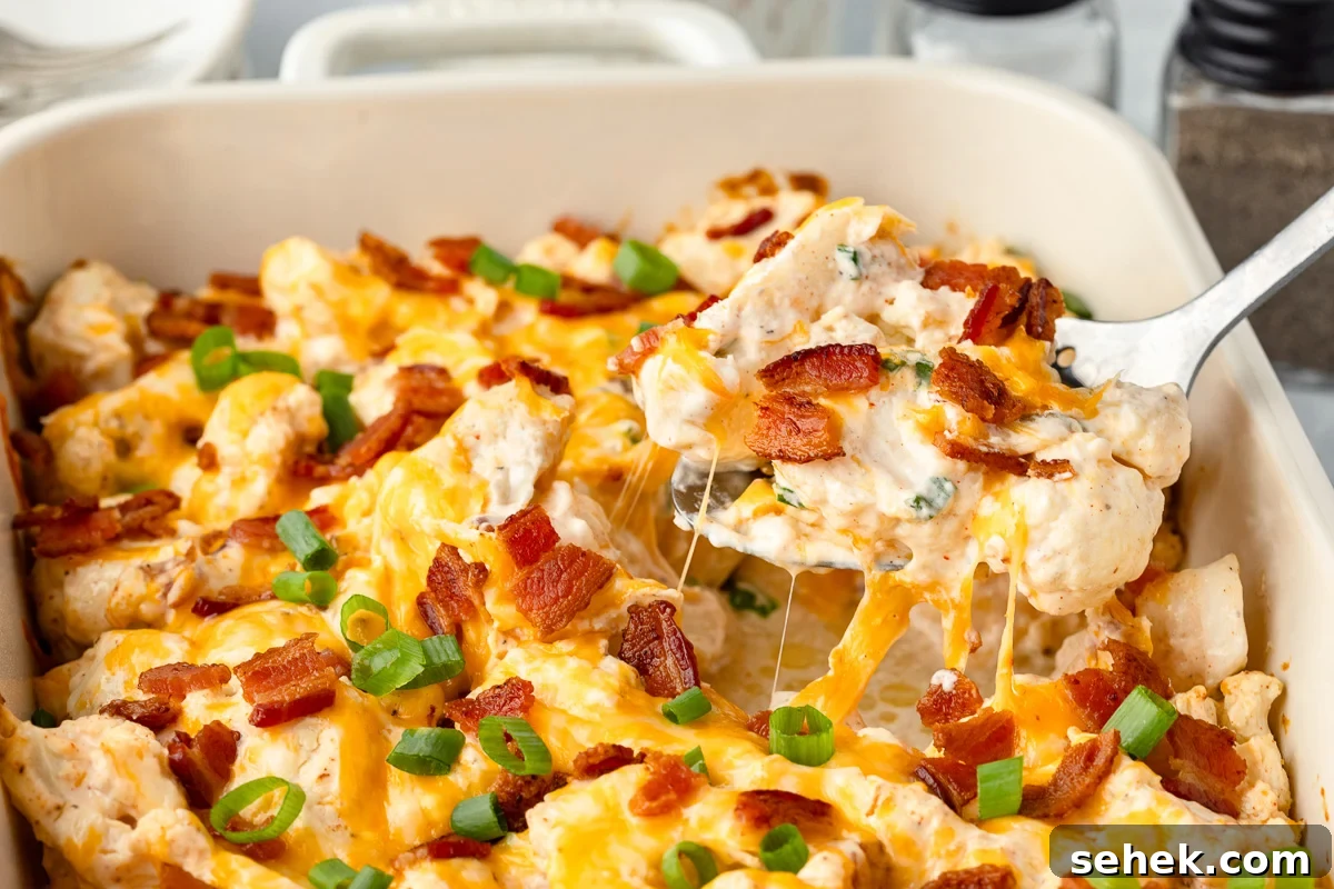 Creamy Loaded Cauliflower Casserole with Bacon and Cheddar 4 Scoop of loaded cauliflower caserole on a spoon.