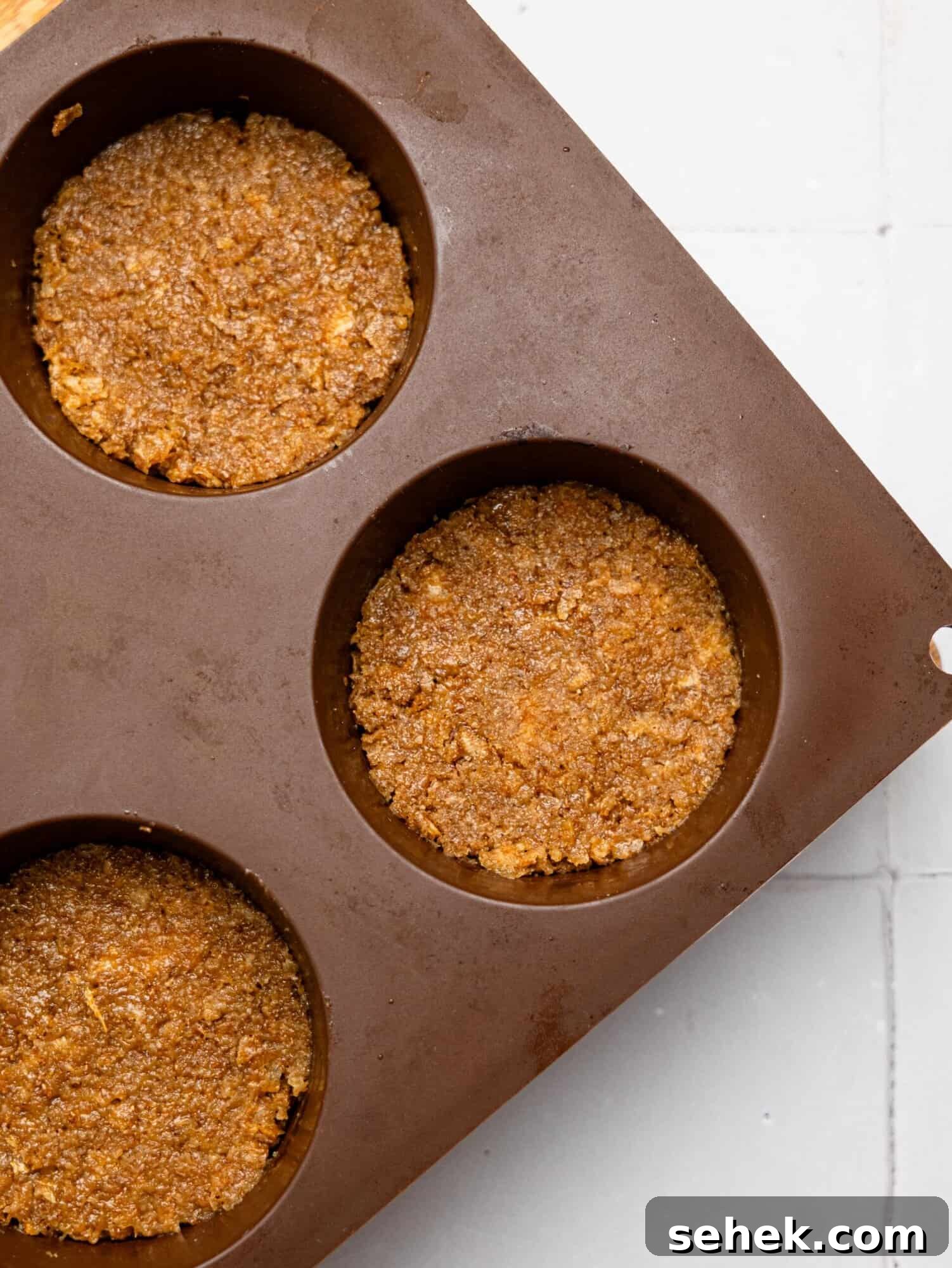Peanut Butter Weetbix Cups bases pressed in a silicone muffin tray.