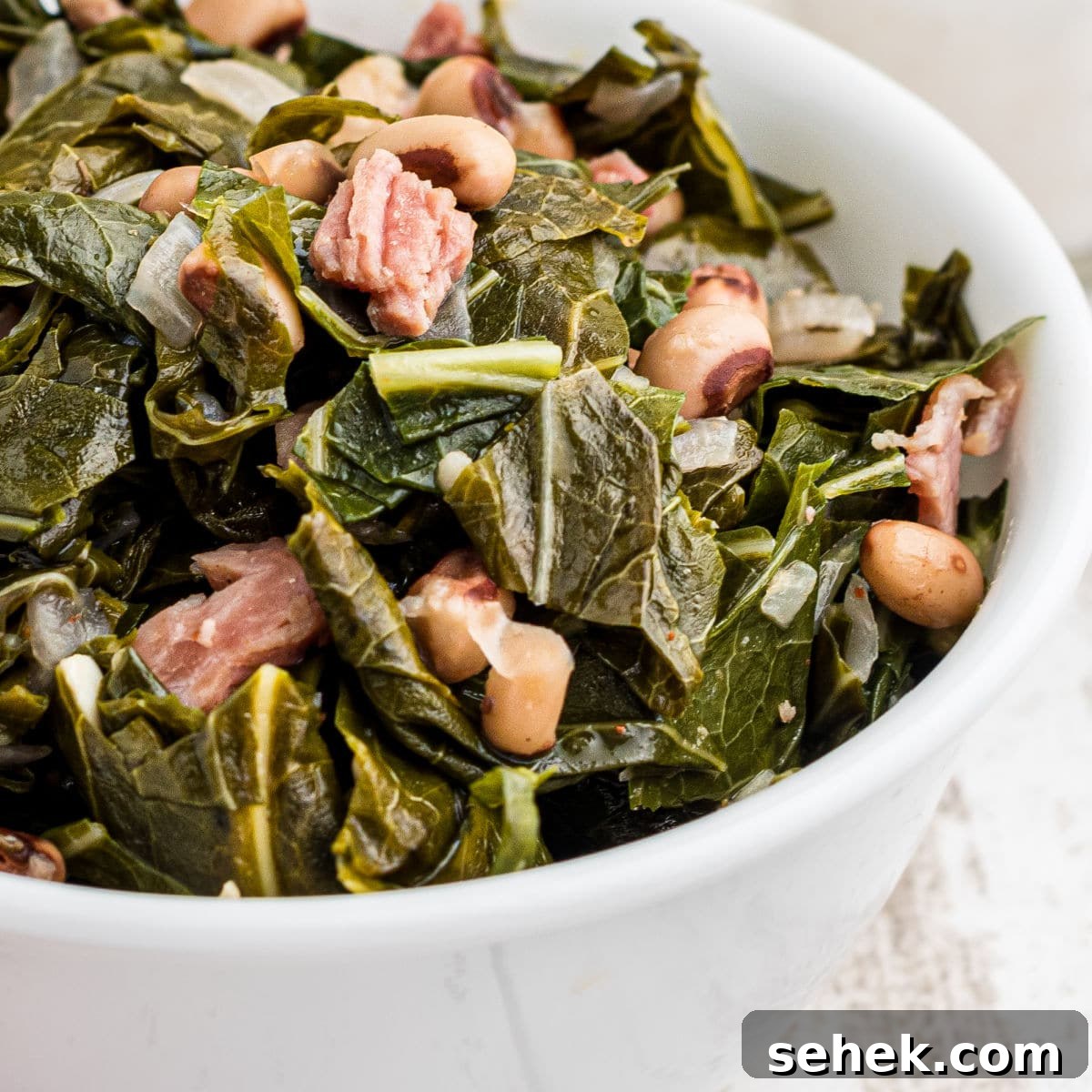 28 Delicious Sides to Serve with Jambalaya 5 Close up of a bowl of southern black eyed peas and collard greens.