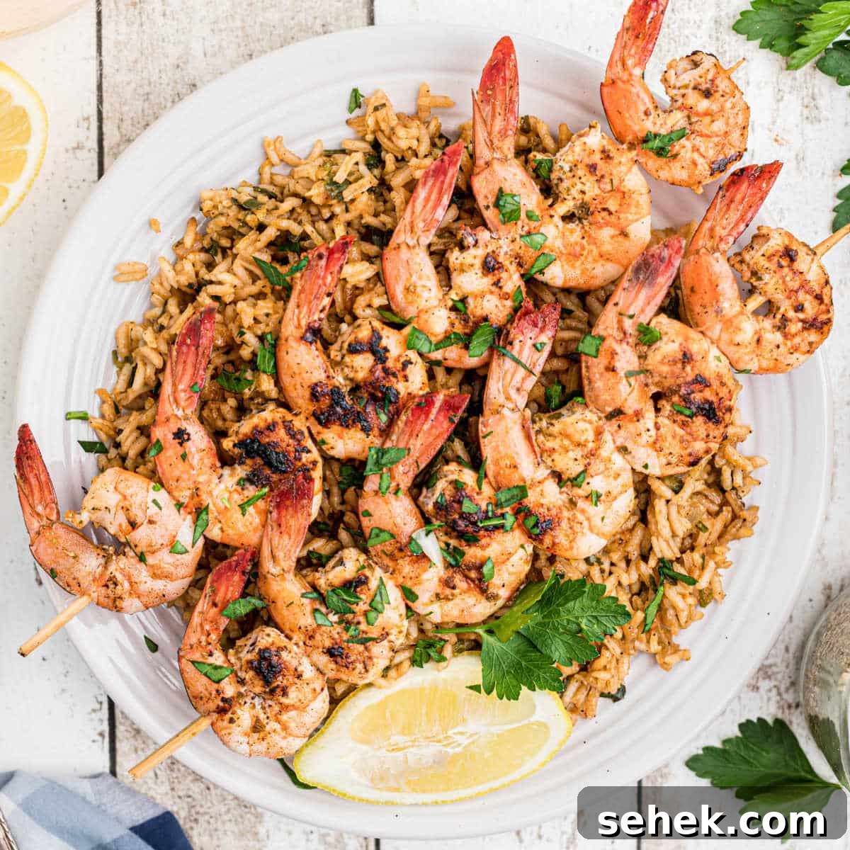 28 Delicious Sides to Serve with Jambalaya 9 overhead shot of some texas roadhouse grilled shrimp on skewers on top of seasoned rice