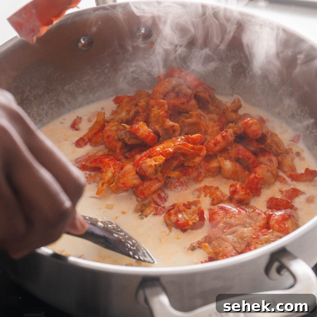 Adding crawfish tails to sauce pan.