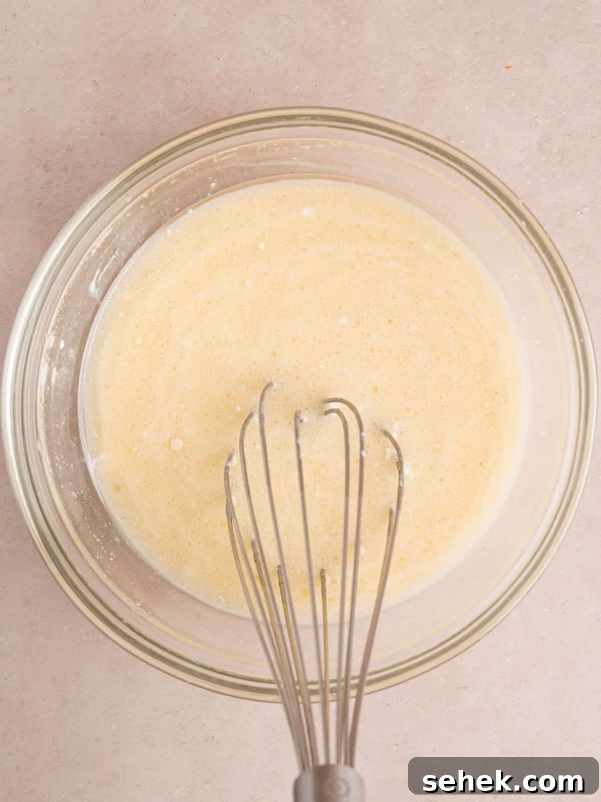 Homemade Belgian Waffles Recipe for Crispy, Fluffy Results 5 Whisking an egg, milk, sour cream, vegetable oil, and vanilla extract in a bowl.
