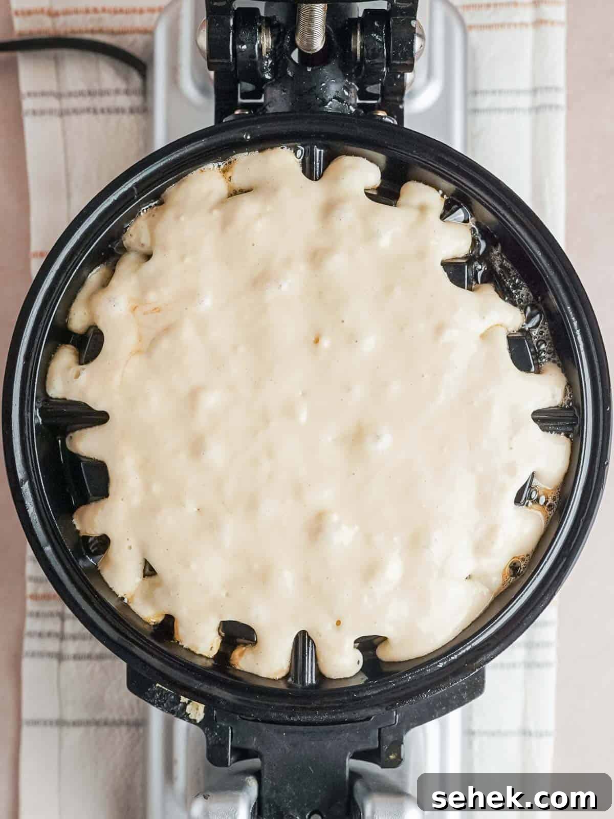 Homemade Belgian Waffles Recipe for Crispy, Fluffy Results 7 Waffle batter in a greased waffle maker.
