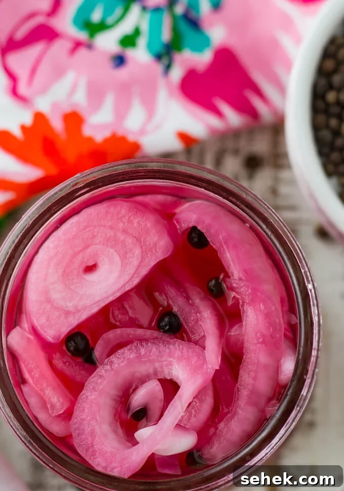 Watermelon Arugula Salad with Feta & Mint 4 An overhead photo of a jar of pickled onions. A pink colorful napkin sits next to it along with a small white bowl of allspice.