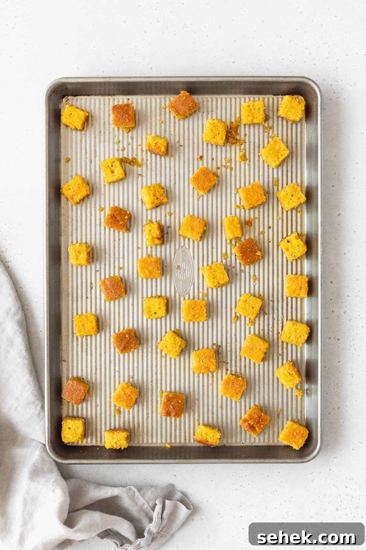 Crispy Cornbread Croutons for Salads and Soups 13 The cornbread croutons on a rimmed cookie sheet before baking.