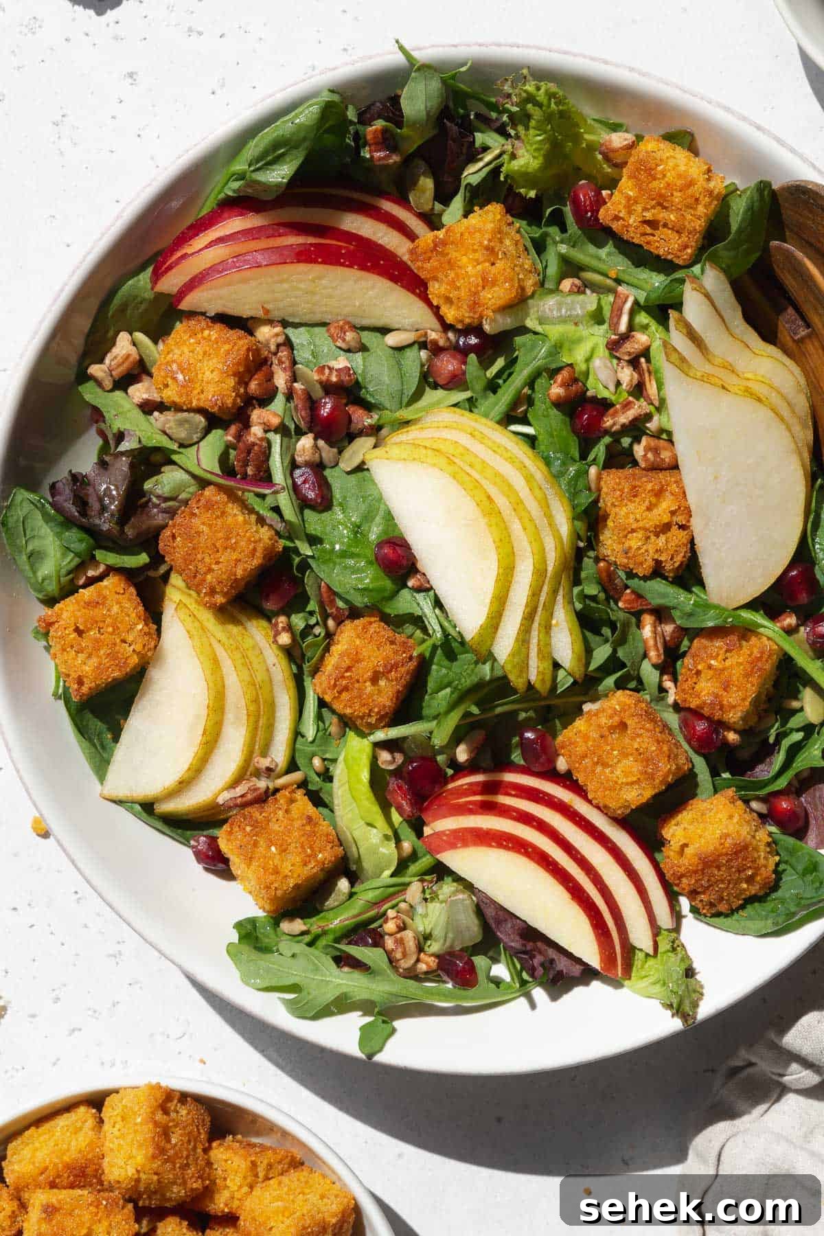 Crispy Cornbread Croutons for Salads and Soups 16 A large bowl of salad with sliced apples, pears, and cornbread croutons.