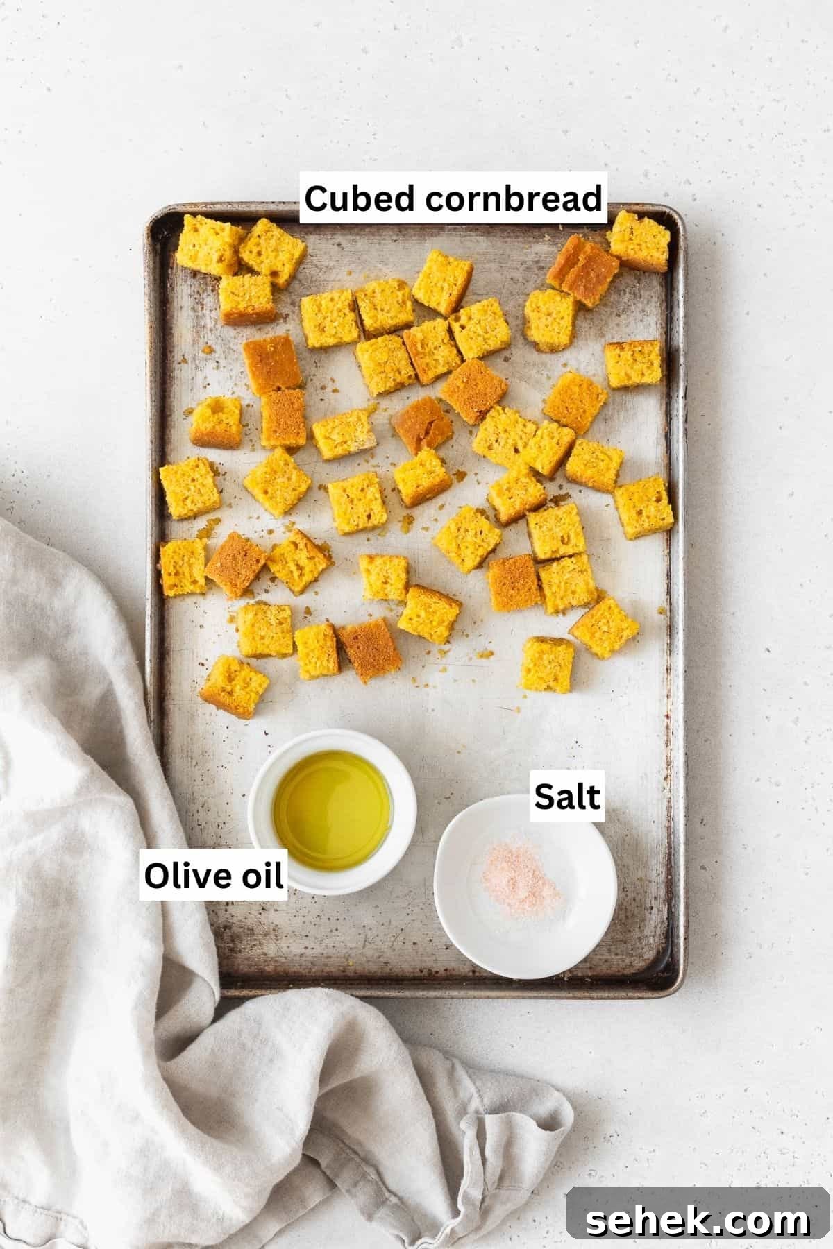 Crispy Cornbread Croutons for Salads and Soups 4 A baking sheet with cubed cornbread, olive oil, and salt.