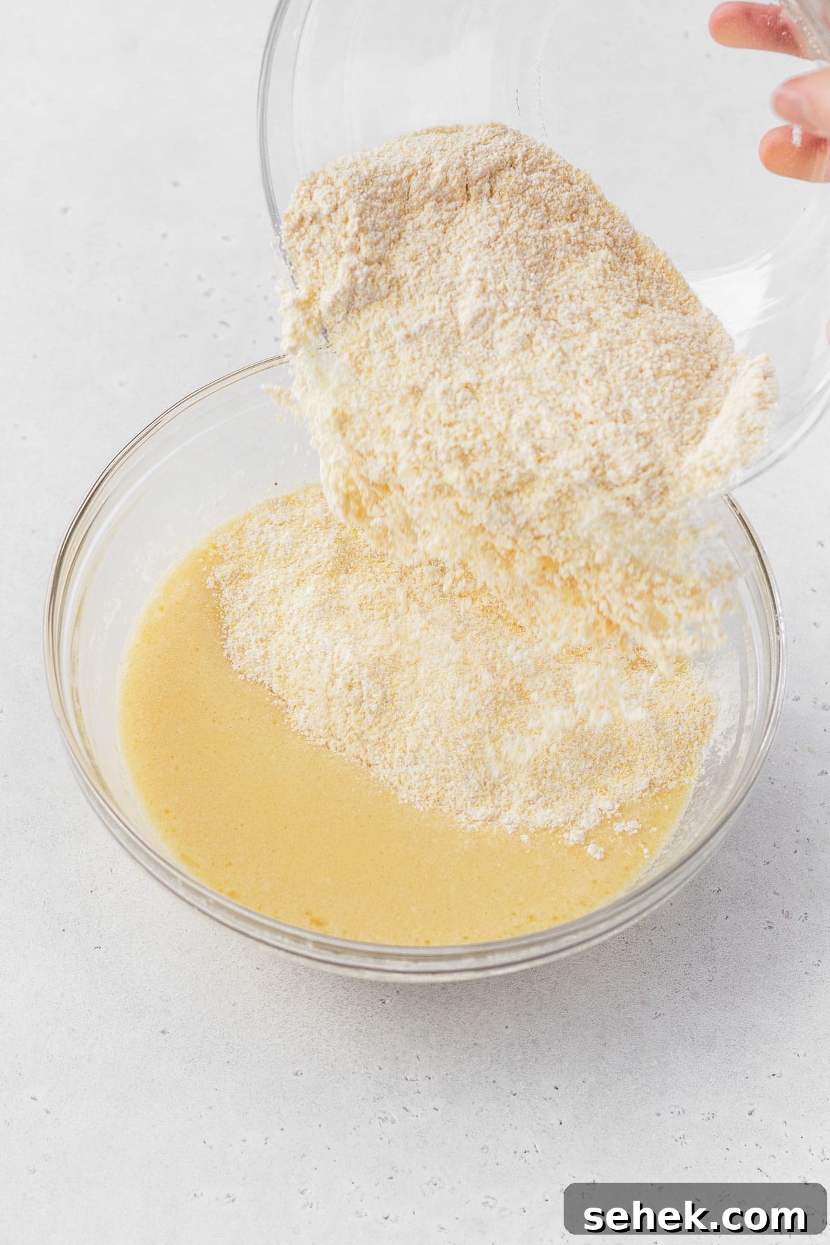 Crispy Cornbread Croutons for Salads and Soups 9 Pouring the dry ingredients into the wet cornbread ingredients.