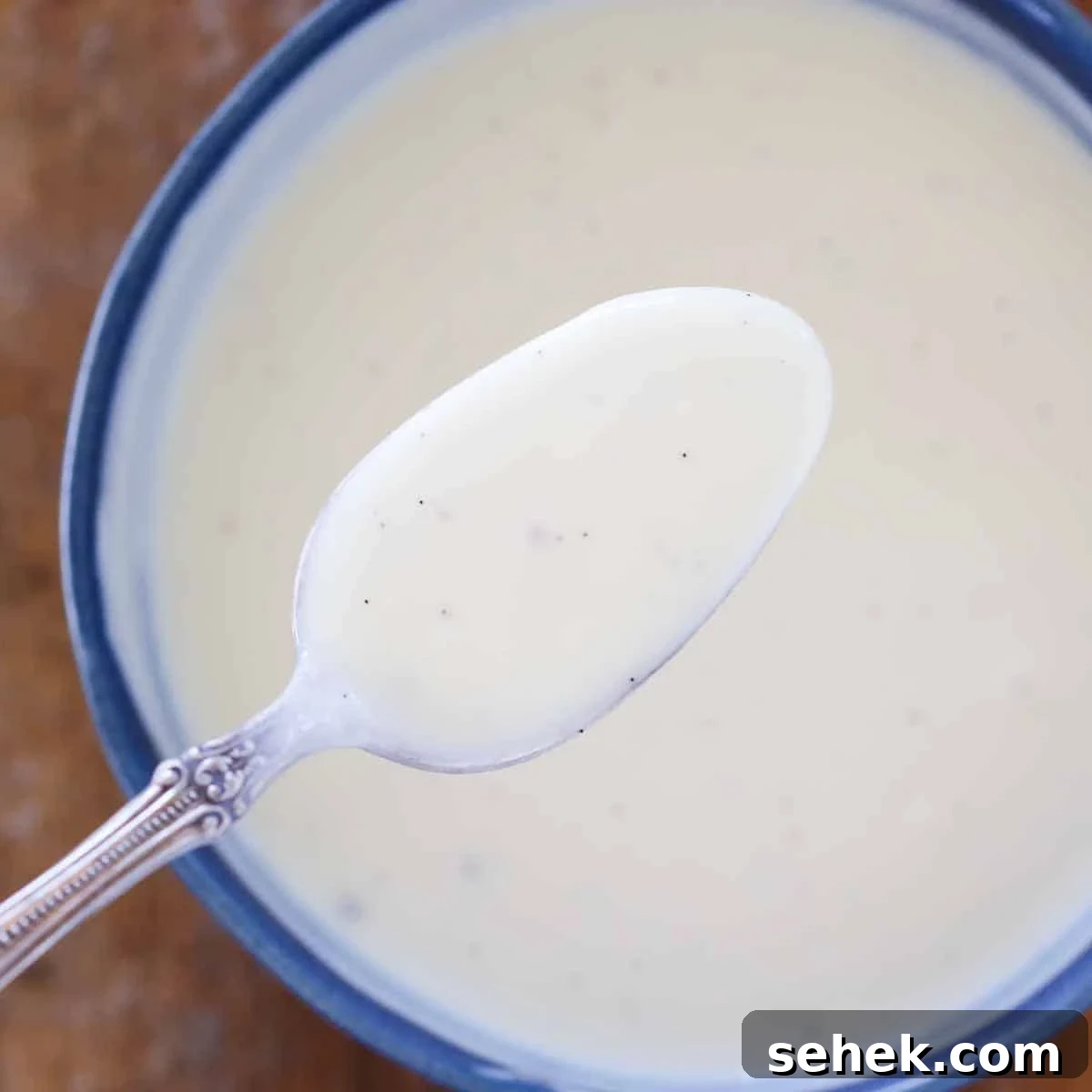 Classic Vanilla Crème Anglaise: French Custard Sauce 2 creme anglaise on spoon over bowl.