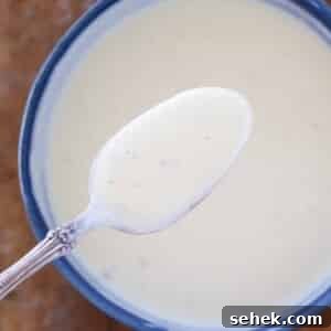 creme anglaise on spoon over bowl.