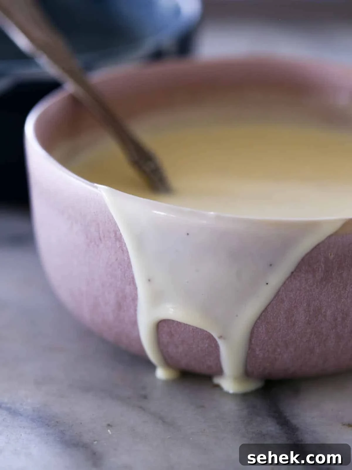 Classic Vanilla Crème Anglaise: French Custard Sauce 6 creme anglaise dripping down side of pink bowl.