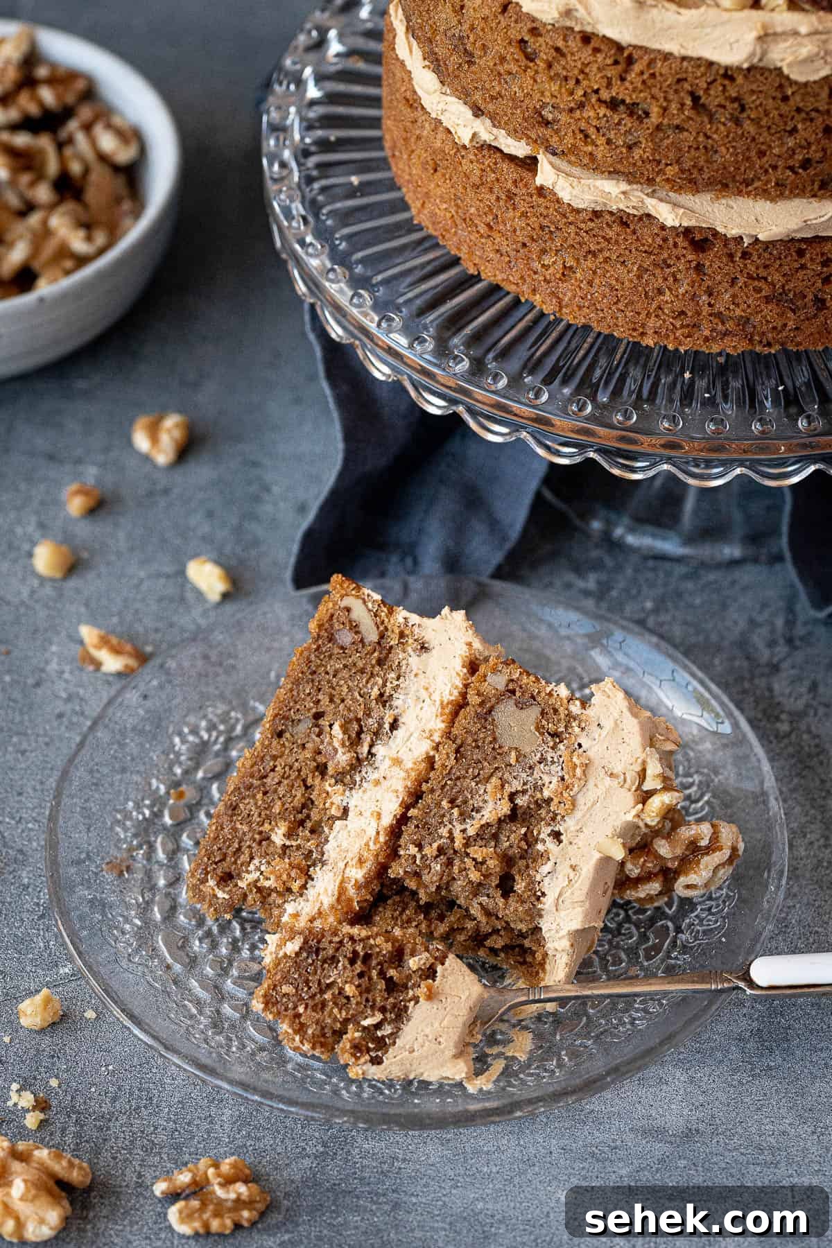 Vegan Gluten-Free Coffee and Walnut Cake Recipe 3 A slice of coffee and walnut cake on a glass plate.