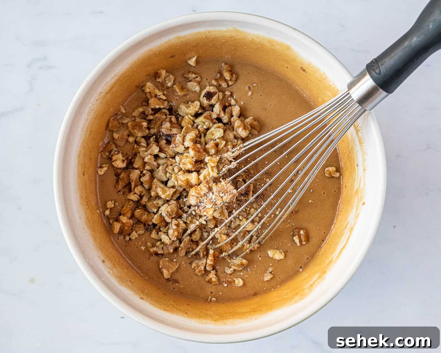 Vegan Gluten-Free Coffee and Walnut Cake Recipe 7 Step 3, the finished batter in a bowl with the walnuts on top.