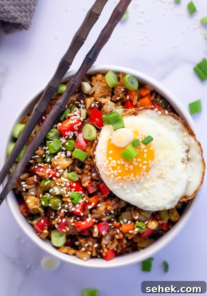 15-Minute Gochujang Fried Rice Recipe 2 Fried rice in a bowl with chopsticks, sunny side up egg and green onions