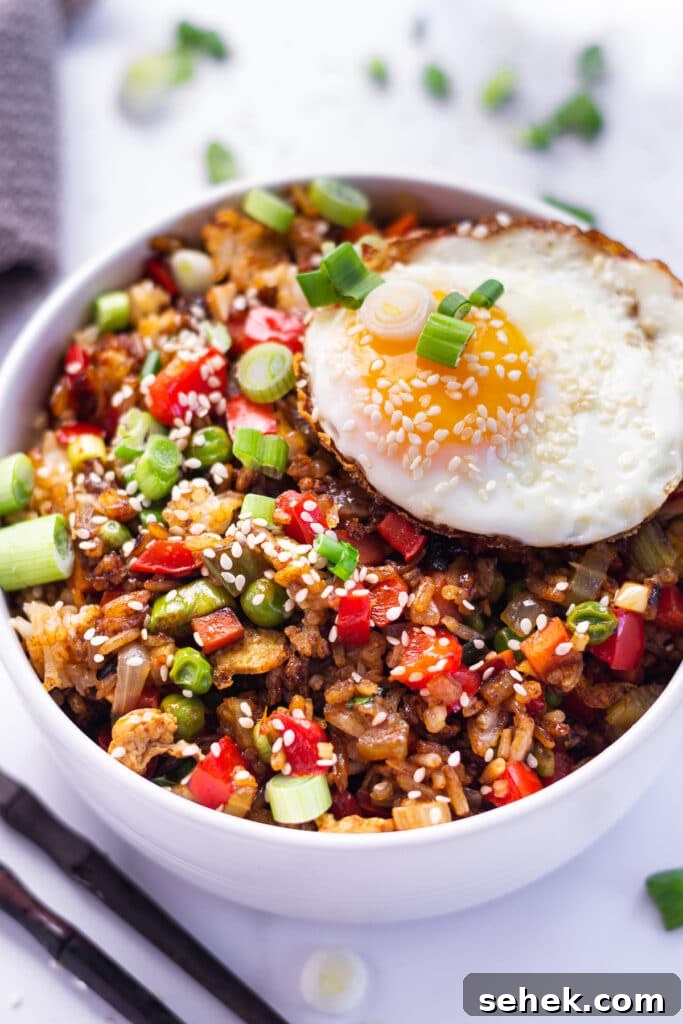 15-Minute Gochujang Fried Rice Recipe 5 Bowl of fried rice topped with a fried egg, sesame seeds and green onions