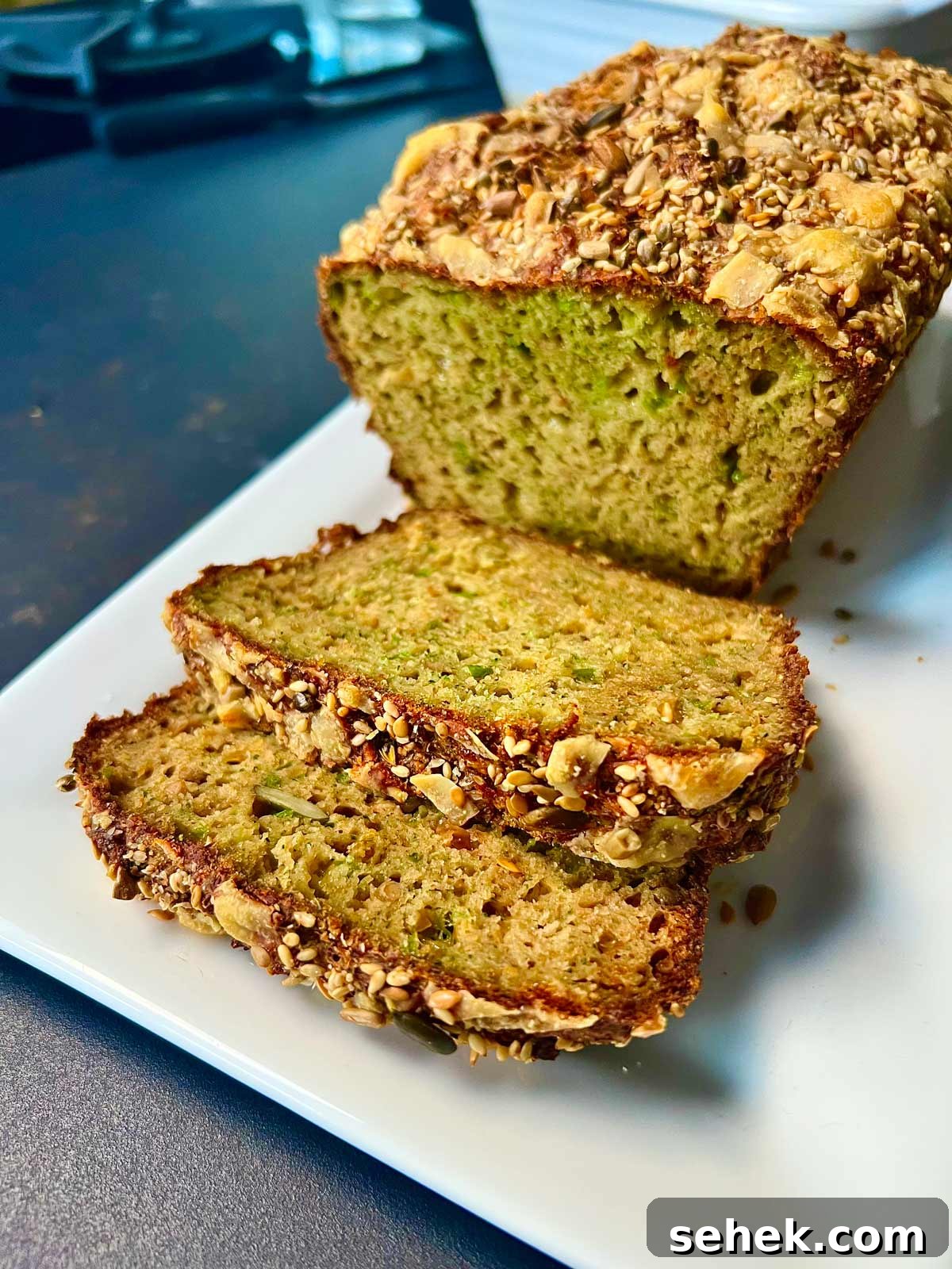 High-Protein Broccoli Bread Recipe 6 Broccoli and cheese bread with mixed seeds, sliced and ready to be served.