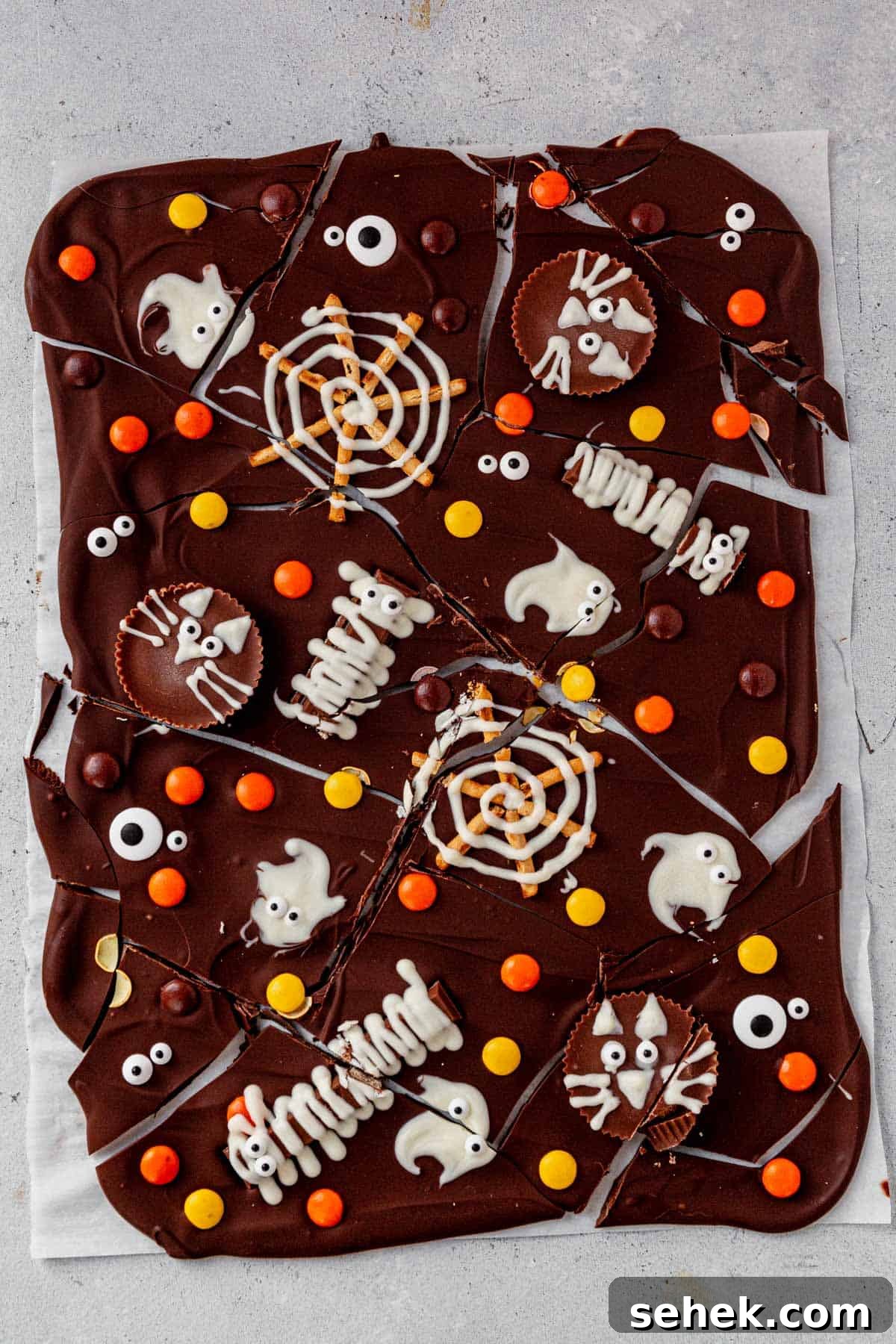 How to Make Spooky Halloween Candy Bark 3 halloween bark broken up into pieces on a piece of parchment paper
