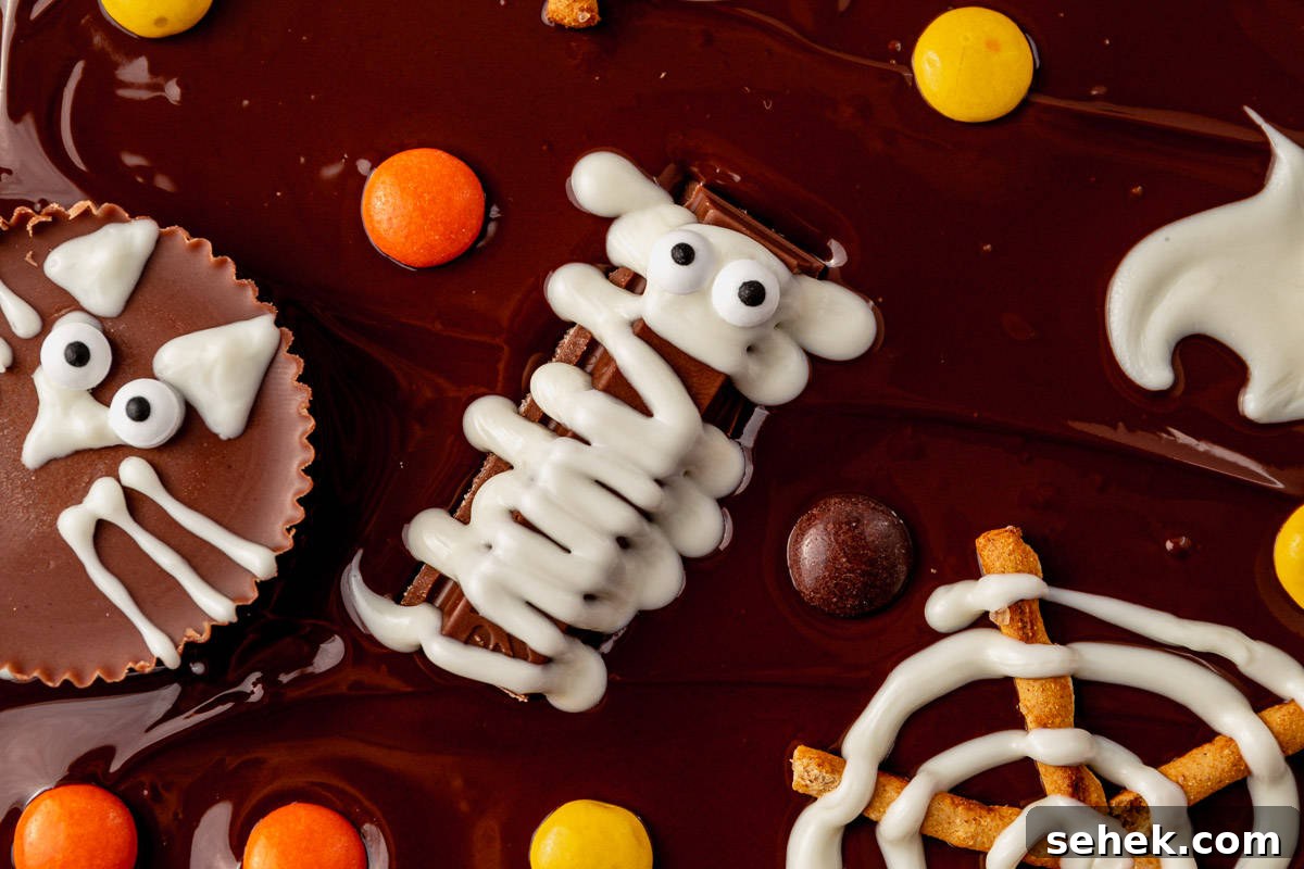 How to Make Spooky Halloween Candy Bark 7 white chocolate covering a kitkat to look like a mummy on melted chocolate