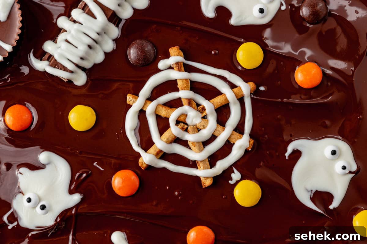 How to Make Spooky Halloween Candy Bark 8 spiderweb design with white chocolate and pretzels on melted chocolate