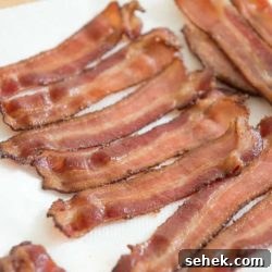 Crispy Oven Bacon: How to Bake Bacon for Even Crispness 8 Oven Cooked Bacon Strips Draining on Paper Towel