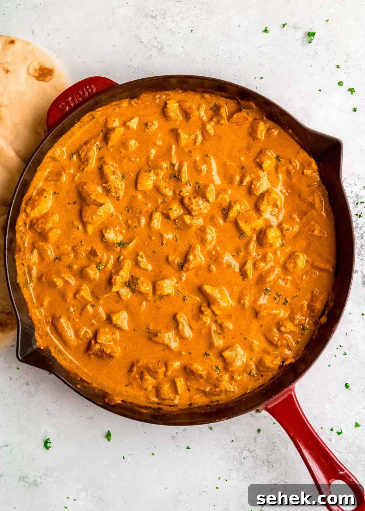 Creamy Indian Butter Chicken Recipe 12 overhead image of cooked butter chicken in red skillet