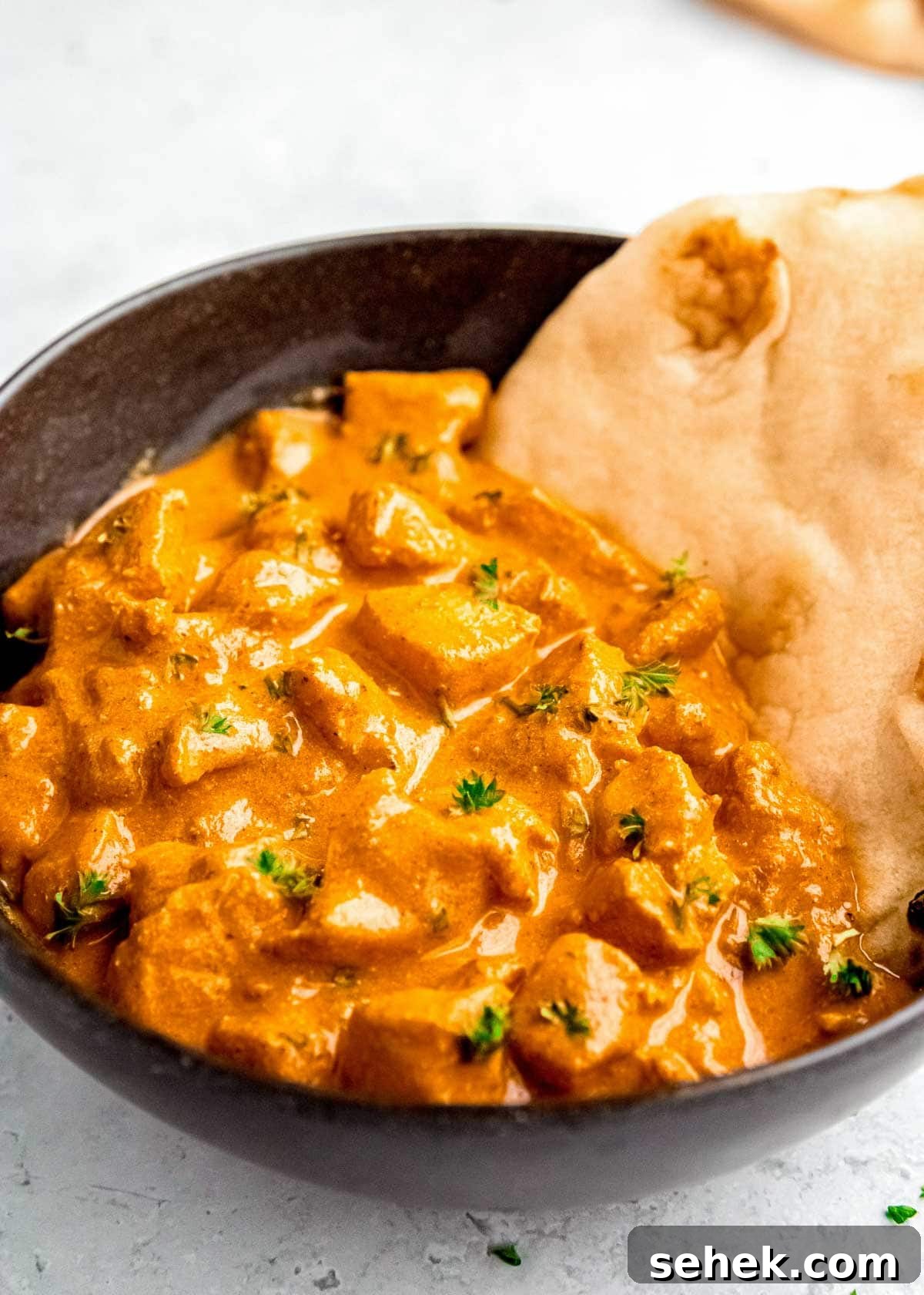 Creamy Indian Butter Chicken Recipe 14 closeup shot showing the creamy Butter Chicken with naan made with this simplified Indian recipe