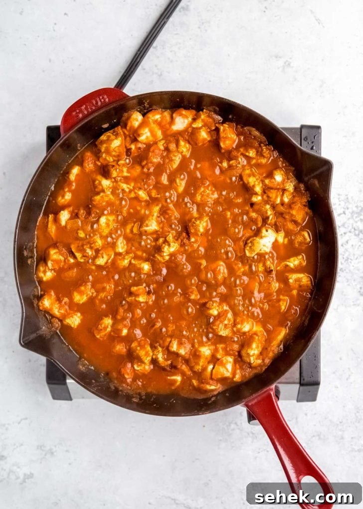 Creamy Indian Butter Chicken Recipe 10 heavy cream being added to butter chicken