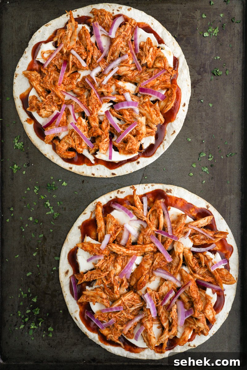 Crispy BBQ Chicken Tortilla Pizzas 5 Two bbq chicken tortilla pizzas on a baking sheet ready to bake