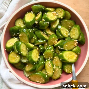 Classic Southern Potato Salad Recipe 14 Freshly sliced cucumbers topped with sesame seeds in a pink bowl, set against a neutral background.