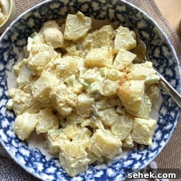 Classic Southern Potato Salad Recipe 15 A bowl of creamy southern potato salad with a mustard based dressing.