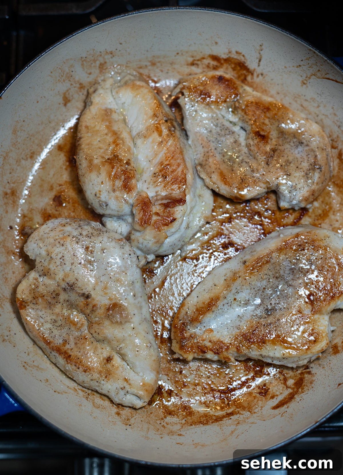 Skillet Chicken with Creamy Mustard Sauce 7 Person flipping chicken in a skillet.