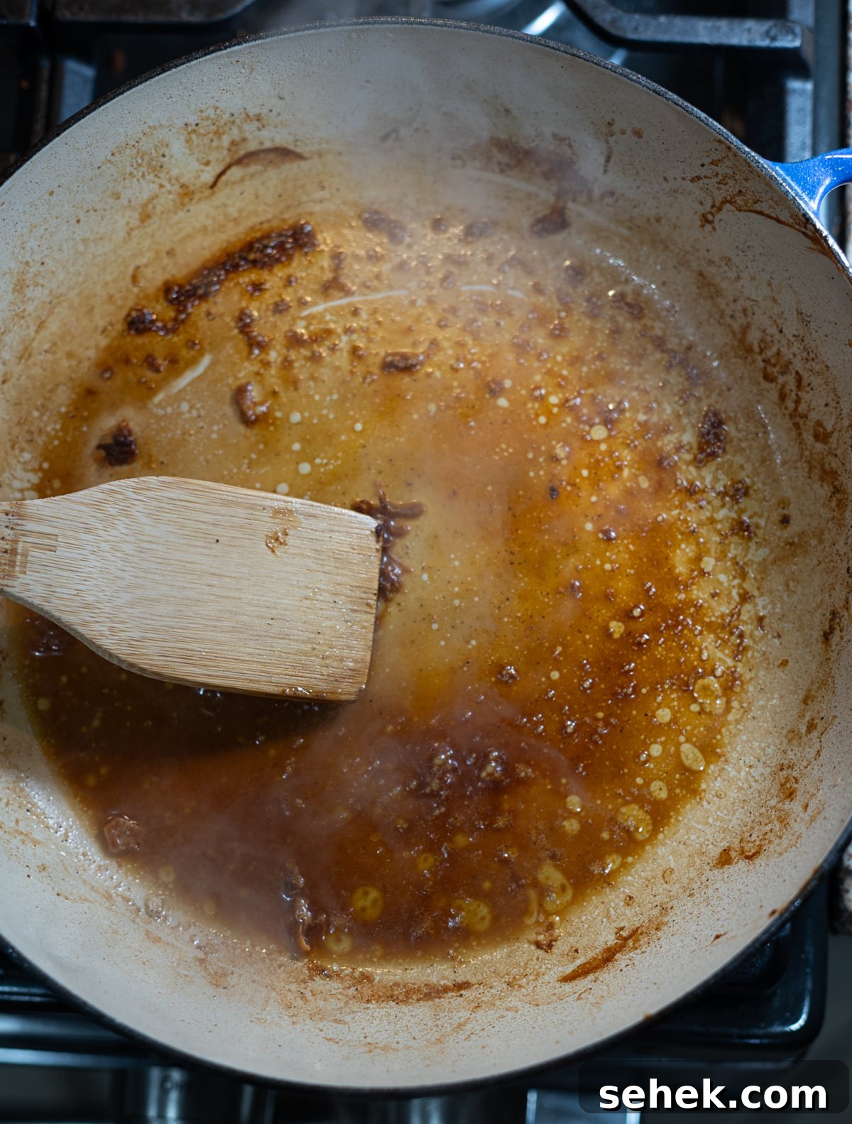 Skillet Chicken with Creamy Mustard Sauce 8 Person adding chicken broth to a skillet for reduction of liquid.