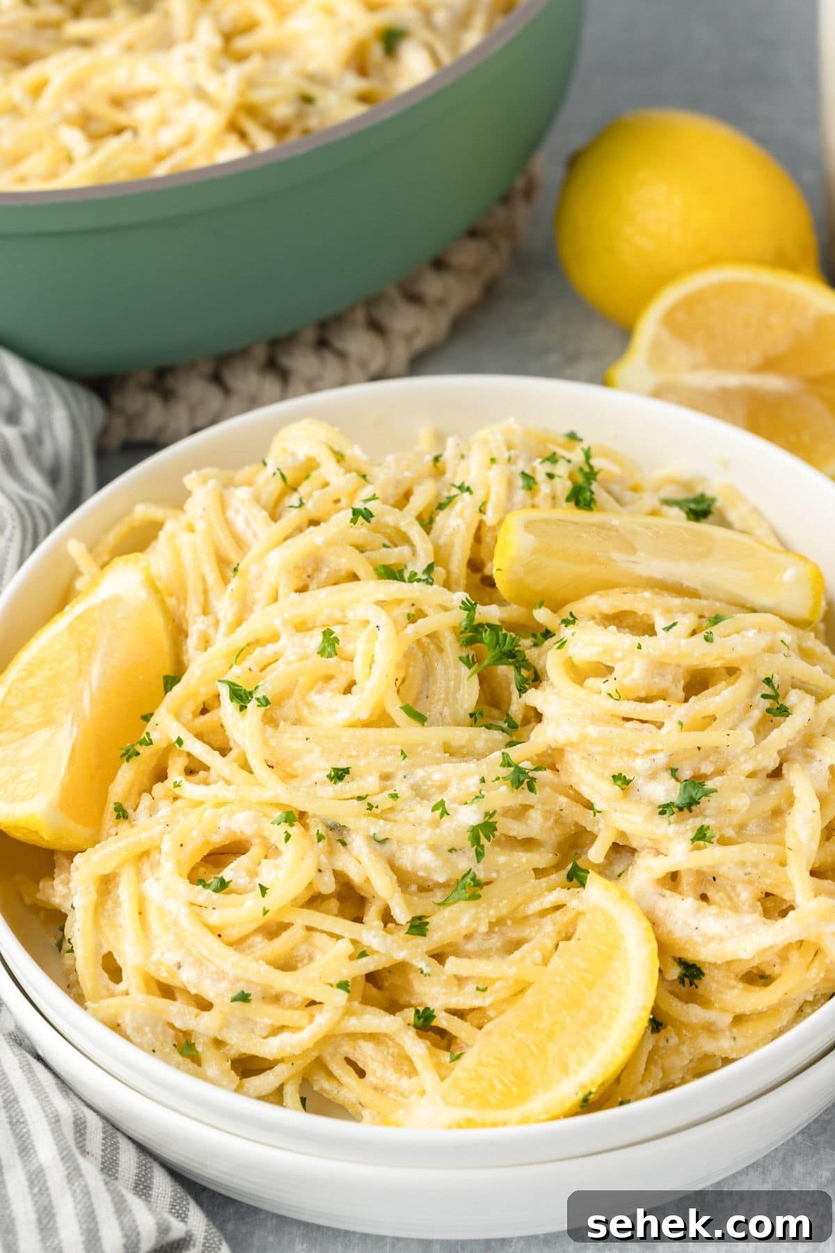 Creamy Lemon Ricotta Pasta with Garlic and Parmesan 2 A bowl of creamy lemon pasta garnished with lemon wedges and fresh parsley.